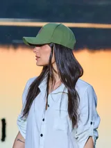 Gorra unisex de color beige con visera curva y aplique de cuero con logo grabado en el frente. Cuenta con hebilla metálica posterior para ajuste.