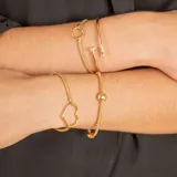 Pulsera de malla extensible en oro amarillo y blanco de 18k, con detalle de esfera central pulida.