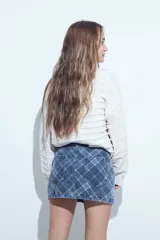 Minifalda de jean con estampado cuadrillé en tonos azules, de corte recto y estructura clásica con bolsillos.