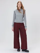 Polera de cuello alto confeccionada en tela rib color gris, con mangas largas y hombreras. Presenta detalles de pespuntes en hilo negro en las costuras de los hombros, cuello, puños y ruedo.