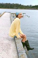 Sweater de punto tejido color amarillo, de corte holgado y cuello alto.