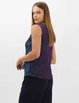 Conjunto de tres piezas compuesto por una musculosa recta, un cardigan liviano de frente abierto con mangas 3/4 y un pantalón de seda fría. La musculosa y el cardigan están confeccionados en tejido plisado con hilos metalizados tornasolados. Incluye collar removible y forro interno a tono.