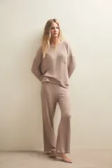 Conjunto de pijama compuesto por una remera de manga larga con bolsillo frontal y un pantalón de corte recto, ambos confeccionados en tejido de punto acanalado.