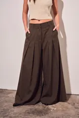 Pantalón wide leg de tiro alto color marrón oscuro, confeccionado en mezcla de viscosa y lino. Cuenta con bolsillos laterales y pinzas frontales que aportan amplitud y movimiento.