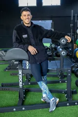 Calza larga deportiva azul con estampado de alas en la parte inferior.