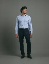 Camisa de vestir de manga larga con diseño de rayas verticales finas en color celeste y blanco. Presenta cuello clásico, cierre frontal con botones y un bolsillo en el pecho.