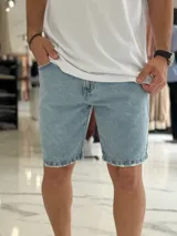 Bermuda de jean de corte slouchy en color celeste claro, con efecto deslavado y detalles de roturas sutiles en los dobladillos.