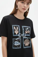 Remera marrón de manga corta y cuello redondo, de corte holgado, con estampado frontal alusivo a frutos del mar y texto "fruits de mer".