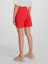 Short de jean de tiro alto, color rojo, con cierre frontal de botón y cremallera, y bolsillos laterales.