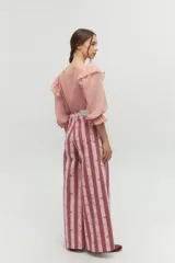 Blusa color rosa pálido de algodón con mangas cortas abullonadas y volados en el escote.