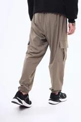 Pantalon cargo negro de corte holgado, con bolsillos laterales con solapa y puños elásticos en los tobillos. Cuenta con cintura elástica con cordón de ajuste.