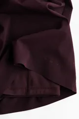 Short deportivo de doble capa color bordó, de corte estándar con cintura elástica fruncida y calza incorporada con bolsillo portacelular.