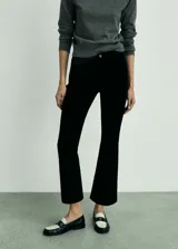Pantalón de pana estilo boot cropped con tiro alto, cierre de cremallera y botón, trabillas y diseño de cinco bolsillos.