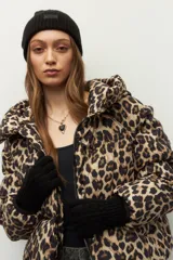 Gorro tejido con diseño de ochos, color negro, con etiqueta de marca en la parte frontal.