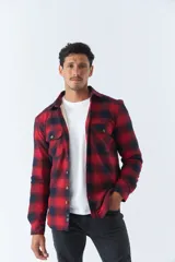 Sobrecamisa de algodón a cuadros color ladrillo, con interior de corderito, cierre con botones, bolsillos tipo cartera y logo en goma. El modelo usa talle M.