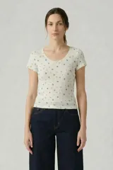 Remera de punto acanalado con estampado floral pequeño, cuello redondo con detalle de encaje y lazo central, y mangas cortas.