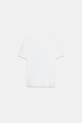 Camiseta blanca de manga corta y cuello redondo, con aplicación de organza y texto negro a contraste en el pecho.