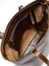 Bolso tote de cuero natural color beige, con doble asa de hombro, costuras visibles y cierre de broche.