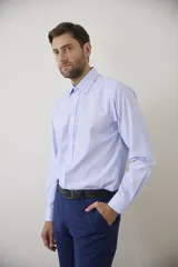 Camisa de vestir blanca de manga larga, con cuello clásico y cierre frontal de botones. Presenta un corte entallado que se adapta a la silueta.