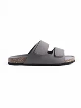 Sandalia de dos tiras con cierre de velcro, confeccionada en material símil cuero color gris. Cuenta con plantilla anatómica con base de corcho y suela de goma negra.