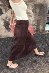 Falda midi de corte acampanado confeccionada en tejido con efecto ante color bordó. Presenta tiro medio, trabillas en la cintura y cierre frontal con cremallera y gancho metálico.