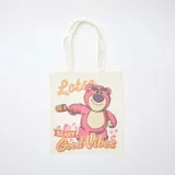 Tote bag de tela color crudo con estampado frontal del personaje Lotso de Toy Story, acompañado por la frase 'Lotsa Beary Good Vibes' y pequeños dibujos de fresas.