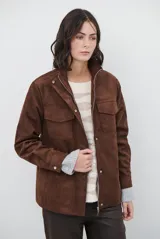 Chaqueta de gamuza en tono marrón oscuro, con cuello alto, cierre frontal con cremallera y botones a presión, bolsillos frontales con solapa y cinturón ajustable en la cintura.