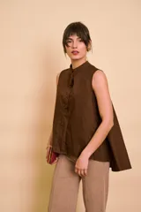Blusa sin mangas de color marrón, con cuello mao y cierre frontal con botones.