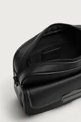 Bandolera de diseño compacto con acabado texturizado. Cuenta con un compartimento principal con cierre de cremallera, un bolsillo frontal con cierre magnético y un bolsillo interior con cremallera. Incluye una correa de hombro ajustable y extraíble.