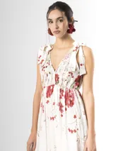 Vestido largo confeccionado en mezcla de tencel y lino, con fondo off white y estampado floral en tonos rosados, rojos y verdes. Cuenta con escote en V pronunciado, breteles anchos ajustables con lazos en los hombros, corte bajo el busto y falda amplia con volados escalonados.