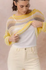 Buzo tejido de punto calado con rayas horizontales multicolor en tonos azul, amarillo, celeste y blanco, con escote bote, mangas largas y hombros caídos. Incluye top básico al tono.