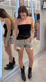 Short de jean de tiro bajo con estampado animal print, diseño corto con bordes desmechados y bolsillos delanteros con forro blanco visible.