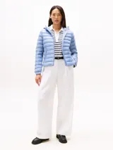 Campera acolchada ultraliviana de nailon reciclado, color celeste claro, con capucha y cierre frontal. Presenta diseño acolchado horizontal y bolsillos laterales con cierre.