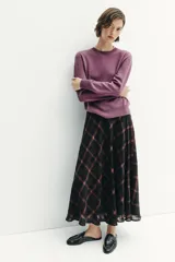 Falda midi de tiro alto con diseño acampanado y estampado de cuadros en tonos negro y marrón. Cuenta con cierre lateral oculto.