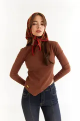 Top de manga larga color blanco, confeccionado en tejido de punto acanalado con diseño irregular y aberturas para los pulgares en los puños.