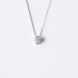 Conjunto de gargantilla y aros de plata con dije de punto de luz en circonia brillante. La cadena es fina y delicada, con un diseño minimalista y elegante.