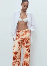 Pantalón tiro medio de tejido fluido con diseño recto y largo, con estampado de palmeras, bolsillos laterales y forro interior.