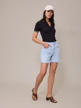 Short de jean elastizado en color azul claro, de tiro alto con cierre y botón metálico, diseño clásico de cinco bolsillos con costuras a contratono.