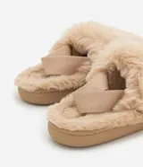 Pantuflas abiertas de peluche color beige, con elástico en el talón y suela marrón.