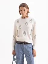 Sweater de tejido con textura de pelo, color blanco, con cuello redondo, mangas largas y bordados de piedras brillantes en forma de llamas distribuidos por toda la prenda.