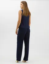 Conjunto de tres piezas compuesto por una musculosa de silueta recta, un pantalón de seda fría con caída fluida y cintura elastizada, y un kimono de tul con bordado floral, frente abierto y mangas acampanadas. Incluye collar largo removible.