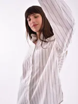 Camisa blanca con rayas verticales finas color beige, de corte amplio y mangas largas con puños abotonados.