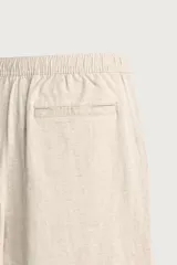 Pantalón de corte relajado confeccionado en una mezcla de algodón y lino. Presenta cintura elástica con cordón ajustable, bolsillos laterales y bolsillos traseros de vivo.