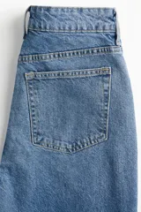 Jean tobillero de tiro alto, color azul medio lavado, con cinco bolsillos y pierna recta ligeramente ajustada.