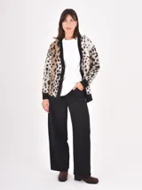 Cardigan de punto con diseño de animal print, cuello en V y cierre frontal con botones. Presenta puños y ruedo en tejido acanalado de color negro.