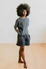 Short de algodón con efecto lavado, corte holgado, cintura elástica con cordón ajustable y ruedo desflecado.