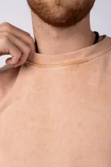 Remeron de algodón rústico con efecto de lavado gastado, corte oversize, cuello redondo y mangas cortas con terminaciones al corte.