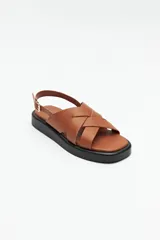 Sandalias color beige con capellada entrelazada y agarre ajustable en el talón. Plataforma de 3cm de alto y suela negra.