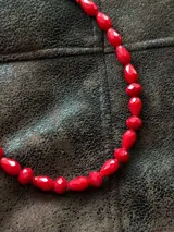 Collar corto de cuentas de cristal facetado en color rojo, con cierre y cadena de extensión de acero quirúrgico.