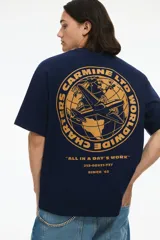 Remera azul marino de corte holgado con cuello redondo y estampado pequeño en el pecho con un avión y texto en color ocre.